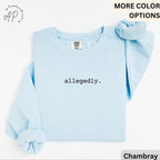 May include: A light blue sweatshirt with the word "allegedly" printed in black. The sweatshirt has long sleeves and a crew neck. A matching scrunchie is placed on the top right. The Comfort Colors brand tag is visible.